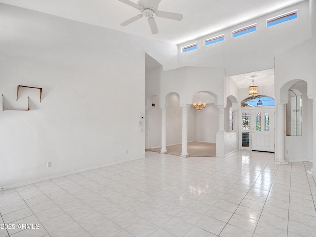 15377 W Catalina Ct, Goodyear, AZ 85395 - unfurnished room featuring plenty of natural light, a towering ceiling, ornate columns, arched walkways, and a chandelier