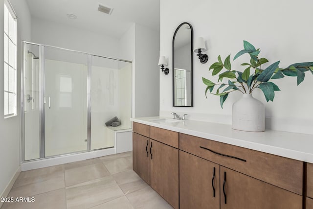 bathroom featuring vanity, a shower with shower door, tile patterned floors, and plenty of natural light