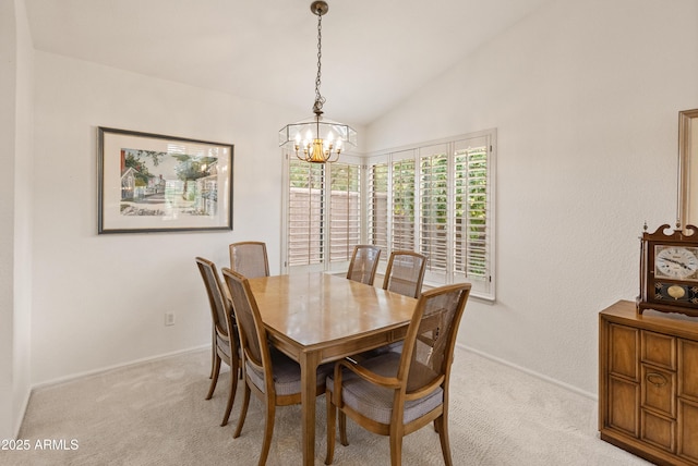 carpeted dining room with an inviting chandelier and lofted ceiling