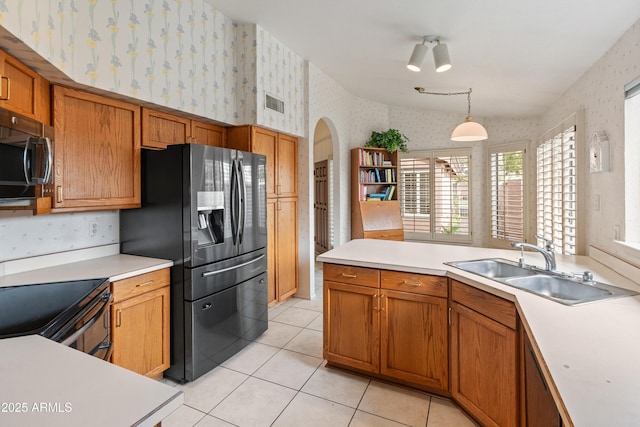 kitchen featuring sink, stainless steel appliances, light tile patterned floors, and pendant lighting