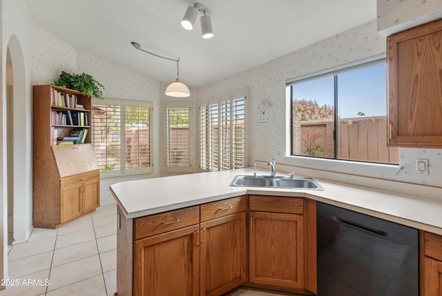 kitchen with dishwasher, light tile patterned floors, sink, decorative light fixtures, and kitchen peninsula