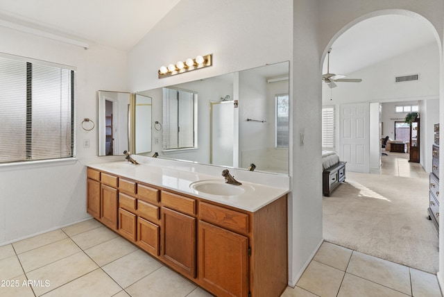 bathroom featuring ceiling fan, a wealth of natural light, and lofted ceiling