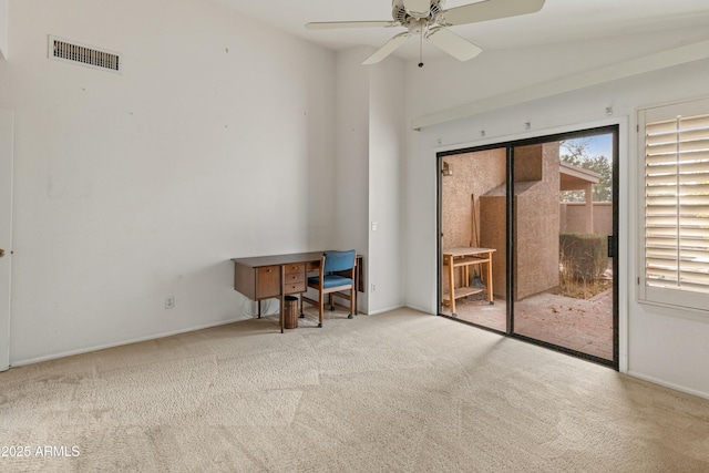 interior space featuring ceiling fan, light colored carpet, and vaulted ceiling