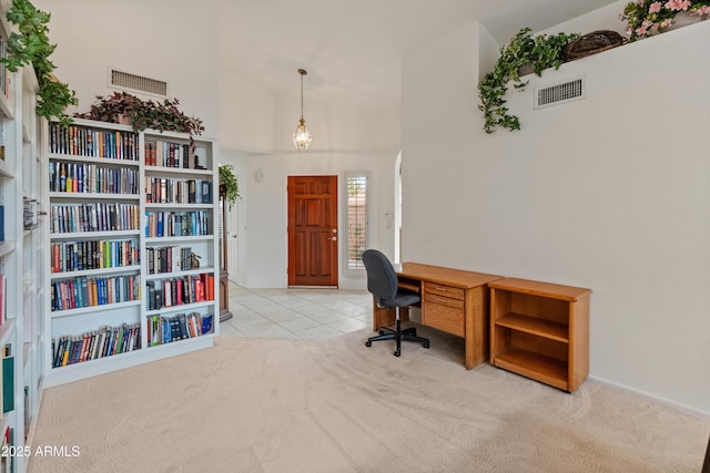 office area with high vaulted ceiling and light tile patterned floors