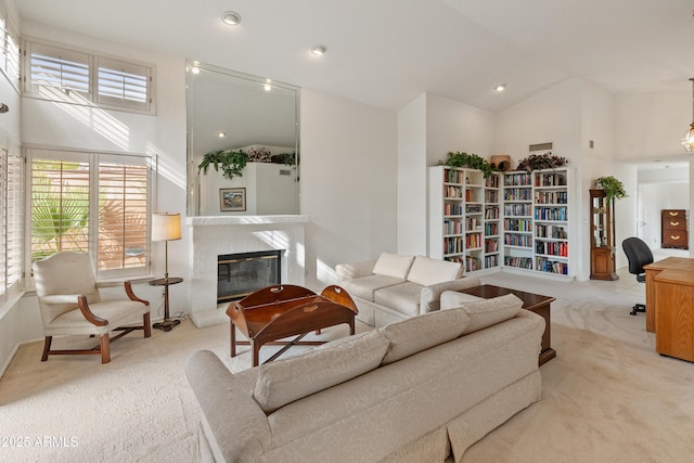 carpeted living room with high vaulted ceiling and a high end fireplace