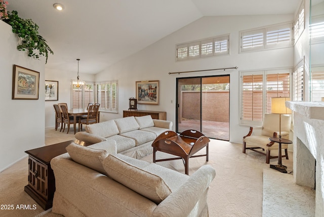 living room with a chandelier, a fireplace, light carpet, and high vaulted ceiling