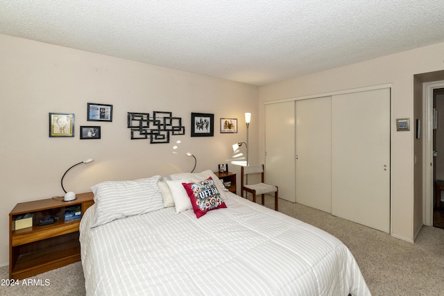 bedroom featuring a textured ceiling, carpet floors, and a closet