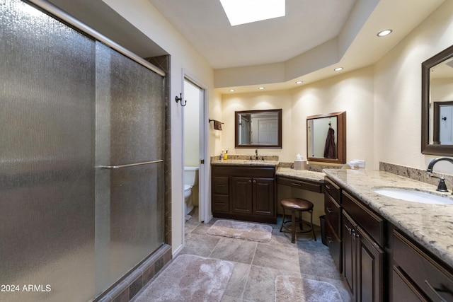 bathroom with vanity, a shower with shower door, and toilet