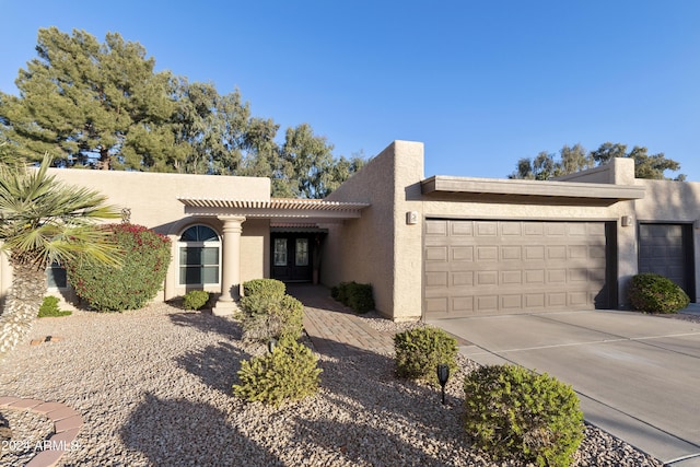 southwest-style home featuring french doors and a garage