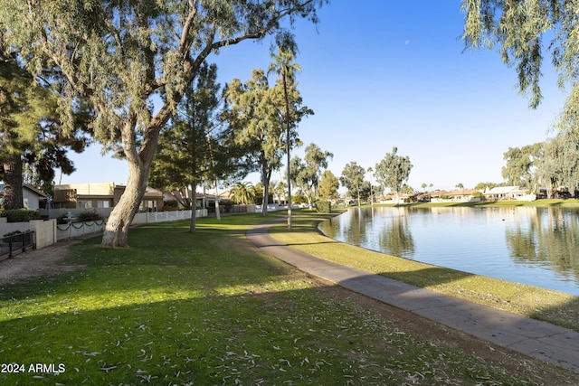 view of home's community with a lawn and a water view