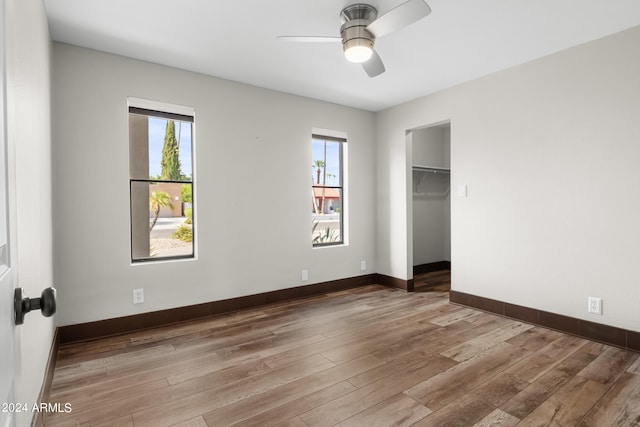 empty room with wood-type flooring, ceiling fan, and plenty of natural light