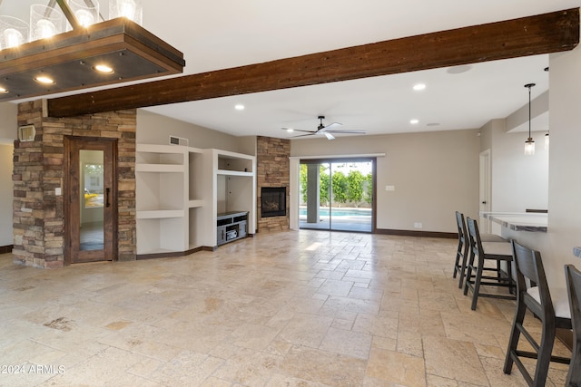 living room with built in features, a fireplace, beam ceiling, light tile patterned flooring, and ceiling fan