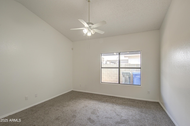 carpeted empty room with ceiling fan, vaulted ceiling, and a textured ceiling