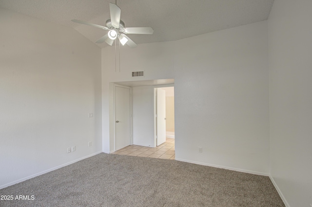 carpeted spare room with ceiling fan, lofted ceiling, and a textured ceiling