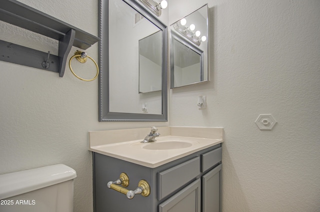 bathroom featuring vanity and toilet