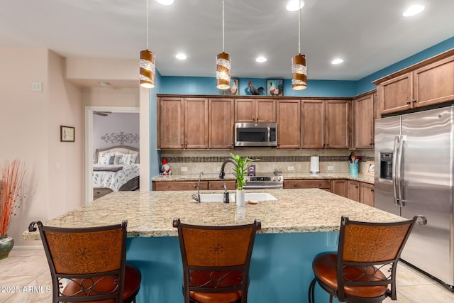 5083 W Buckskin Dr, Eloy, AZ 85131 - kitchen featuring a breakfast bar area, tasteful backsplash, a sink, and stainless steel appliances