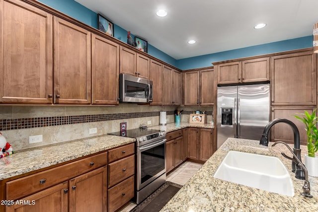 5083 W Buckskin Dr, Eloy, AZ 85131 - kitchen with a sink, brown cabinets, decorative backsplash, and appliances with stainless steel finishes