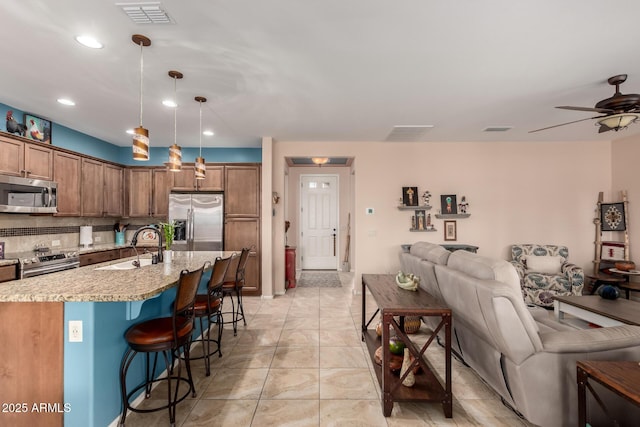 5083 W Buckskin Dr, Eloy, AZ 85131 - kitchen featuring open floor plan, visible vents, a breakfast bar, and appliances with stainless steel finishes