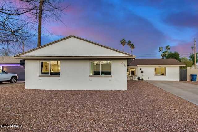 view of front of home featuring concrete driveway and fence