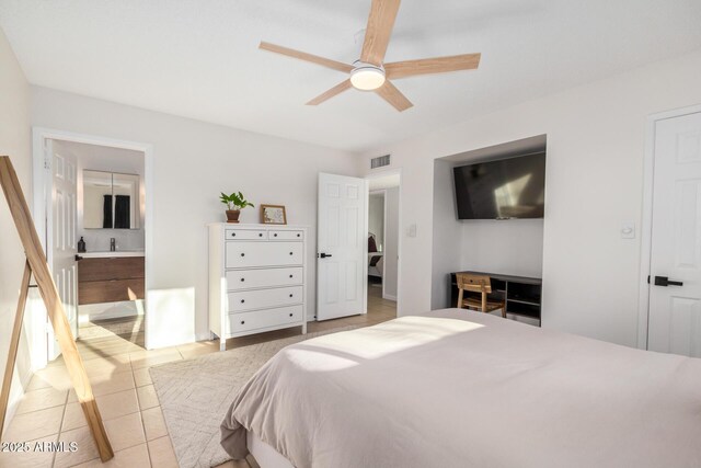 bedroom with light tile patterned floors, visible vents, ceiling fan, and ensuite bathroom