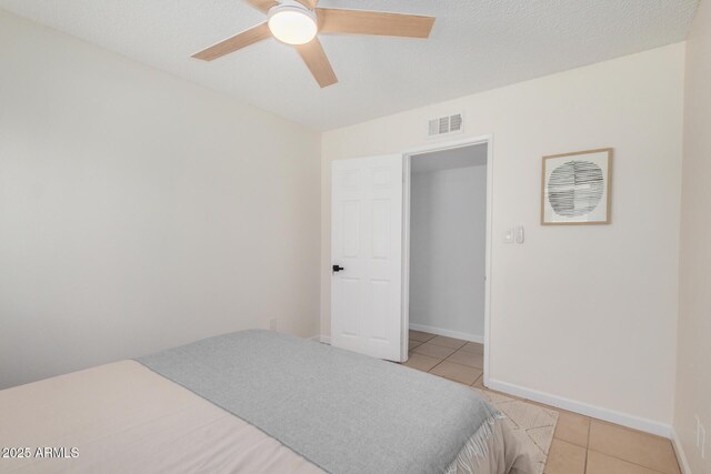 bedroom featuring light tile patterned floors, baseboards, visible vents, and ceiling fan