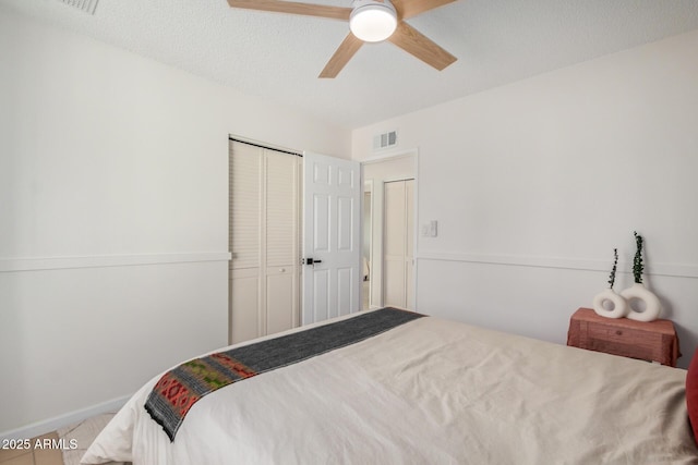 bedroom with a ceiling fan, visible vents, a closet, and a textured ceiling