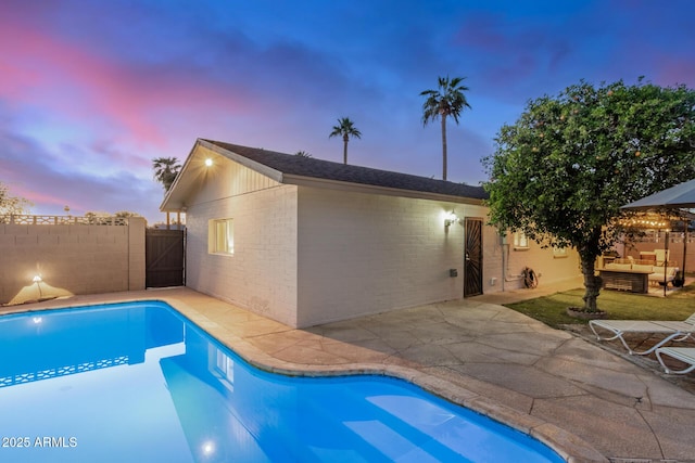 pool at dusk featuring a fenced in pool, fence, and a patio area