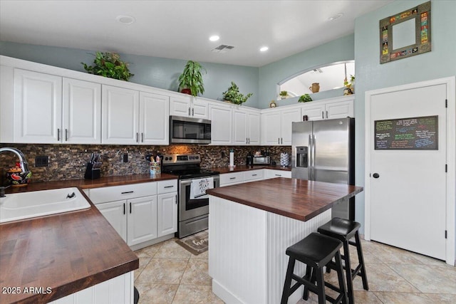 kitchen featuring sink, wooden counters, white cabinets, and appliances with stainless steel finishes