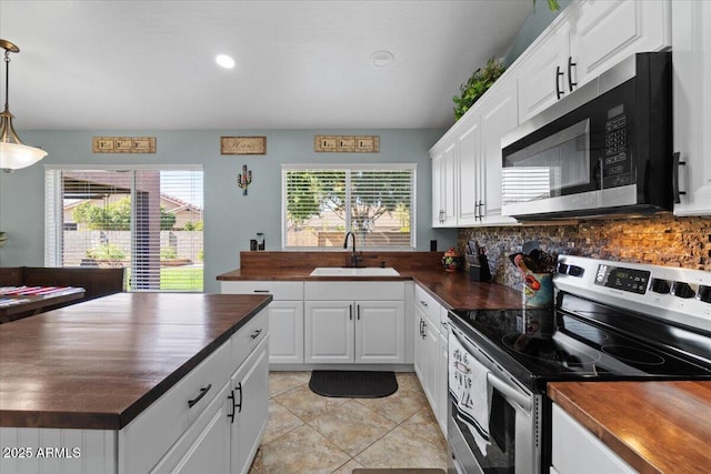 kitchen with sink, butcher block countertops, white cabinetry, decorative light fixtures, and appliances with stainless steel finishes