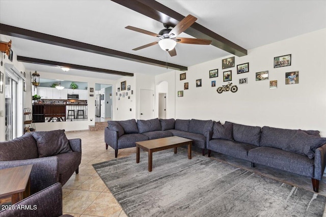 living room featuring ceiling fan, beam ceiling, and light tile patterned floors