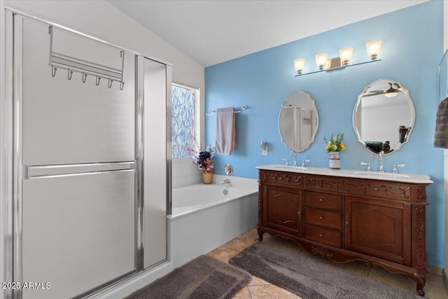 bathroom with tile patterned flooring, vanity, lofted ceiling, and independent shower and bath