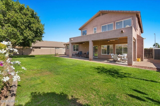 back of property featuring a lawn, a patio, and ceiling fan