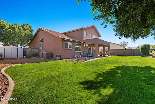 rear view of house featuring central AC, a storage shed, a yard, and a patio area