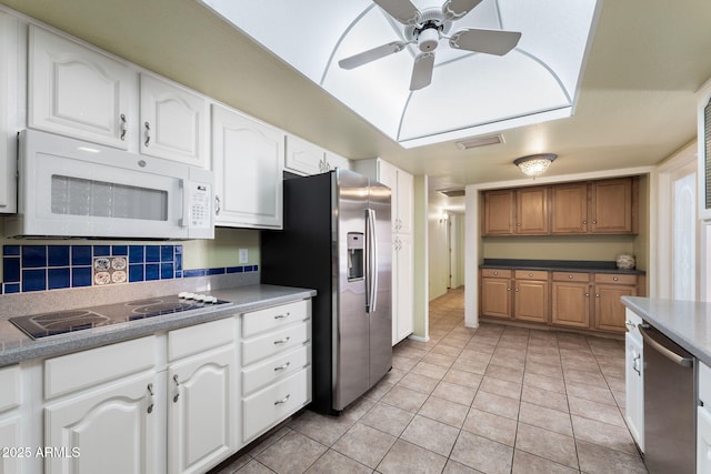 kitchen with white cabinetry, light tile patterned floors, ceiling fan, stainless steel appliances, and backsplash