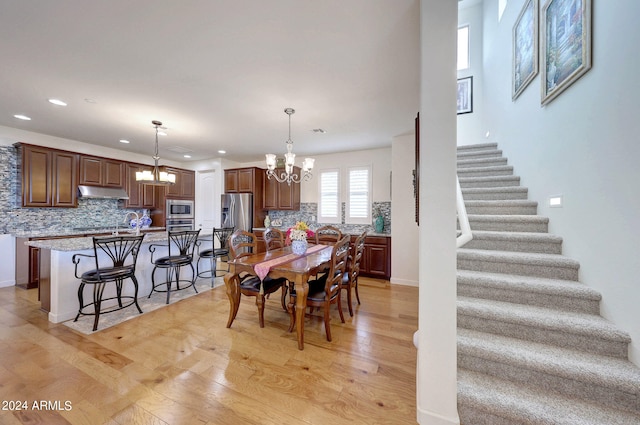 dining space with a notable chandelier and light wood-type flooring