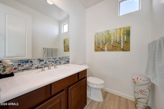 bathroom with decorative backsplash, vanity, toilet, and hardwood / wood-style floors