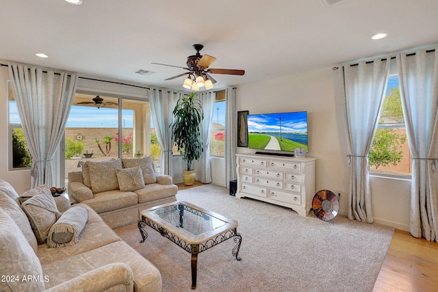 living room with light wood-type flooring, ceiling fan, and a wealth of natural light