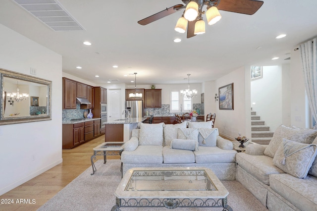 living room with light wood-type flooring, ceiling fan, and sink