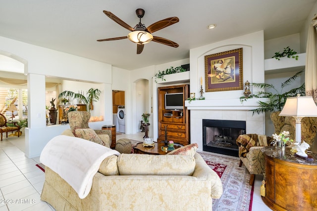 316 W Anderson Ave, Phoenix, AZ 85023 - living area with arched walkways, washer / dryer, light tile patterned flooring, a ceiling fan, and a fireplace