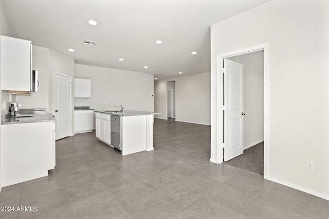 kitchen featuring a center island with sink, visible vents, appliances with stainless steel finishes, white cabinetry, and a sink