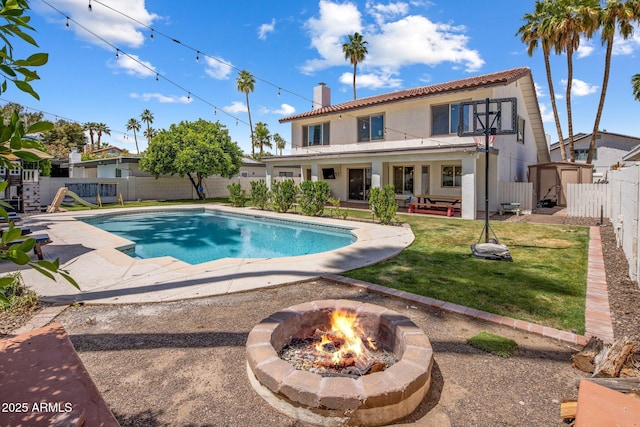 view of pool with a storage shed, a fenced backyard, a fenced in pool, a patio, and a fire pit