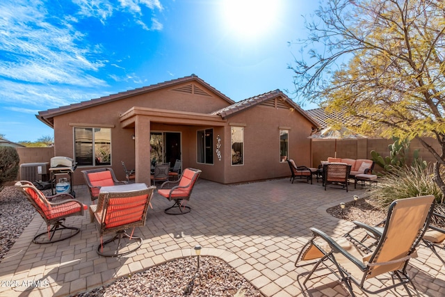 rear view of property with an outdoor living space and a patio