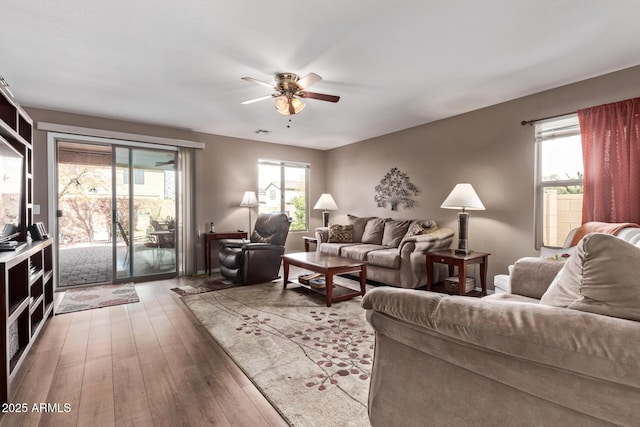 living room featuring hardwood / wood-style flooring, a healthy amount of sunlight, and ceiling fan