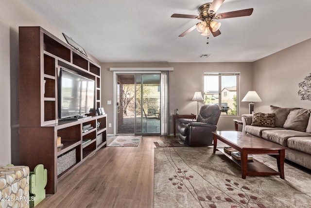 living room featuring hardwood / wood-style flooring, ceiling fan, and plenty of natural light