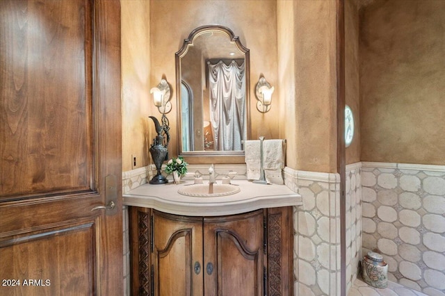 bathroom featuring vanity and tile walls