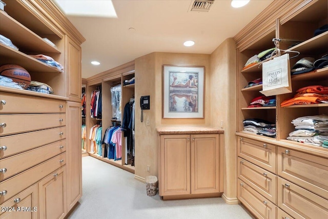 walk in closet featuring light colored carpet