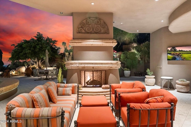 patio terrace at dusk with an outdoor living space with a fireplace