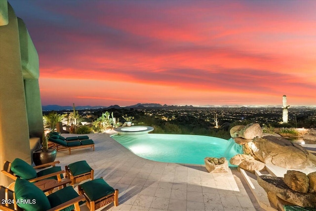 pool at dusk featuring a patio