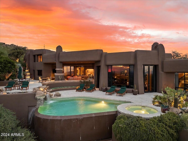 exterior space with a patio area, pool water feature, and a pool with hot tub