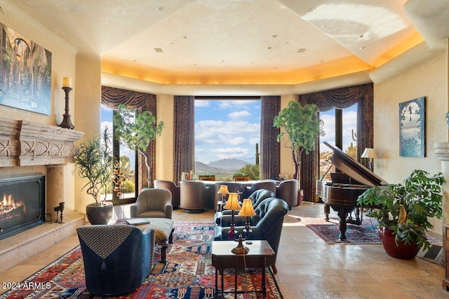 interior space with a mountain view, a tray ceiling, and a wealth of natural light